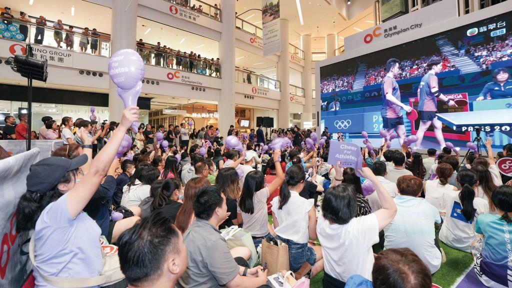 中庭换上「薰衣草紫」赛道，让市民在430吋高清电视前，一同拿著打气道具欣赏直播赛事，提升奥运的炽热氛围。
